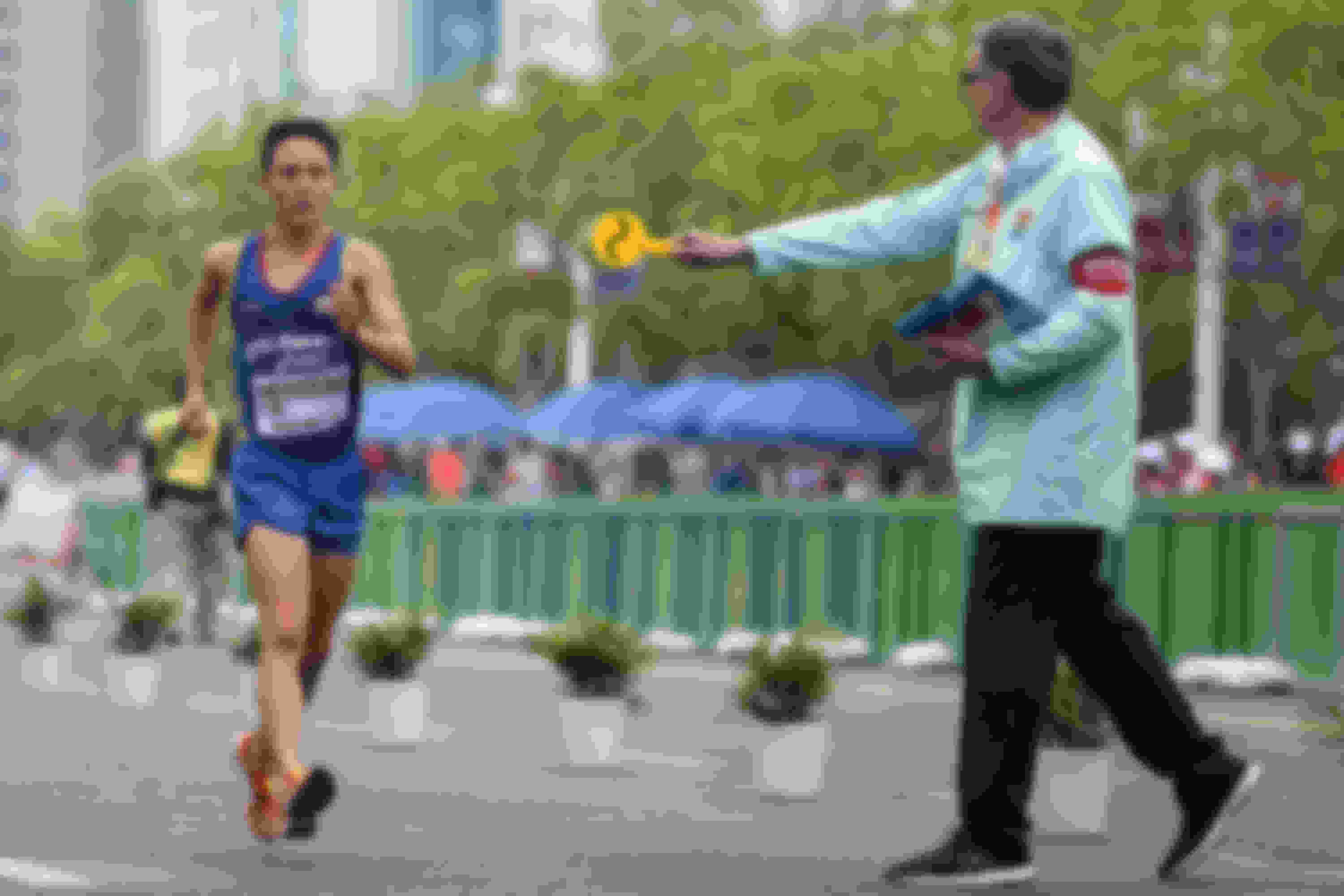 A judge shows a ‘loss of contact’ card to a race walker.
