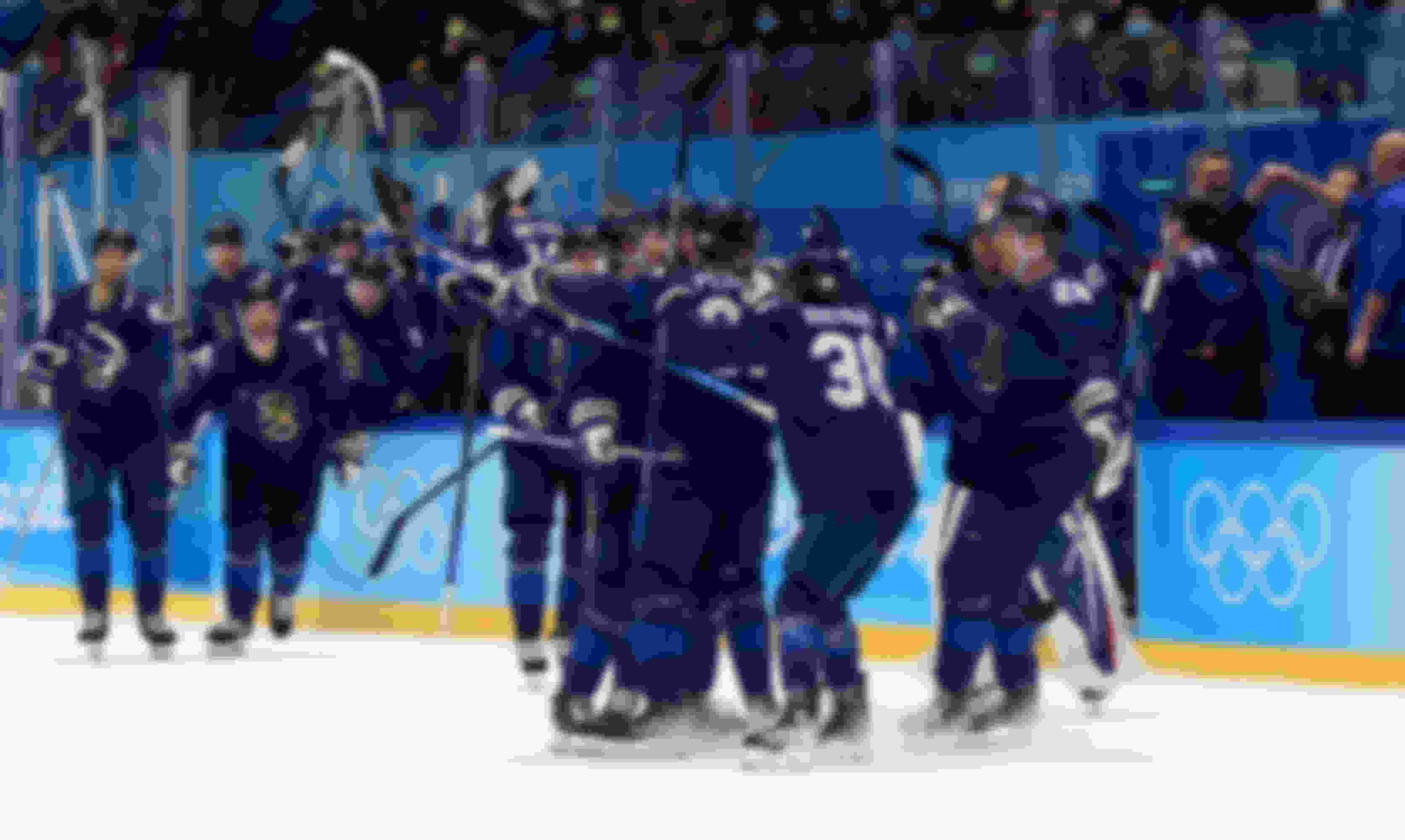 Finland's Harri Pesonen (#82) is mobbed by teammates after his overtime winner against Sweden