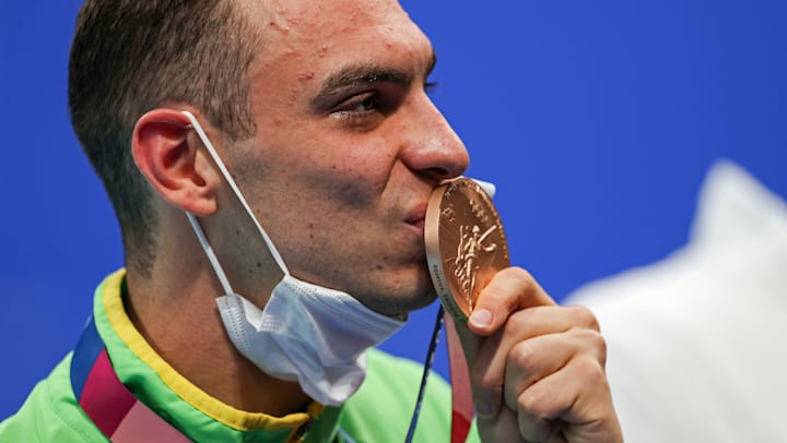 Fernando Scheffer beija sua medalha de bronze dos 200m livre em Tóquio 2020.