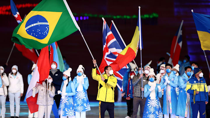O porta-bandeira brasileiro André Barbieri carrega a bandeira do país na Cerimônia de Encerramento dos Jogos Paralímpicos de Inverno Beijing 2022.