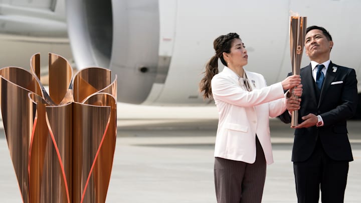 Olympic gold medallists Yoshida Saori and Nomura Tadahiro hold the torch at last year's Flame arrival ceremony.