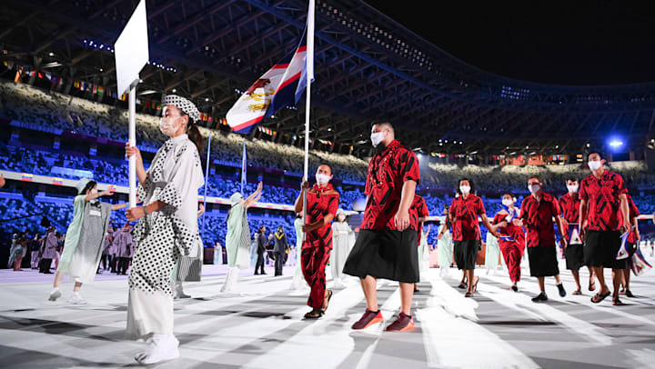 Tilali Scanlan carrega a bandeira da América Samoa com Tanumafili Malietoa Jungblut na cerimônia de abertura de Tóquio 2020