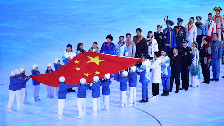 The flag of the People's Republic of China is passed hand to hand as it enters the stadium during the Opening Ceremony of Beijing 2022