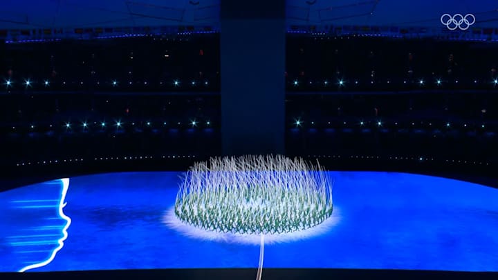 Performers create a dandelion shape at the National Stadium