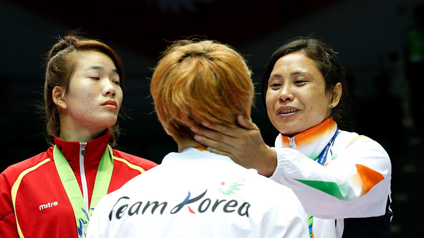 Laishram Sarita Devi (R) habla con Park Ji-na durante la ceremonia de entrega de medallas de peso ligero en Incheon 2014 antes de entregarle su medalla de bronce.
