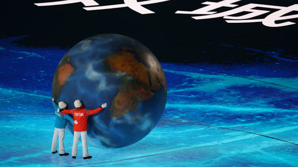 Children representing Milano and Cortina hug a globe as part of the handover ceremony during the Beijing 2022 Winter Olympics Closing Ceremony